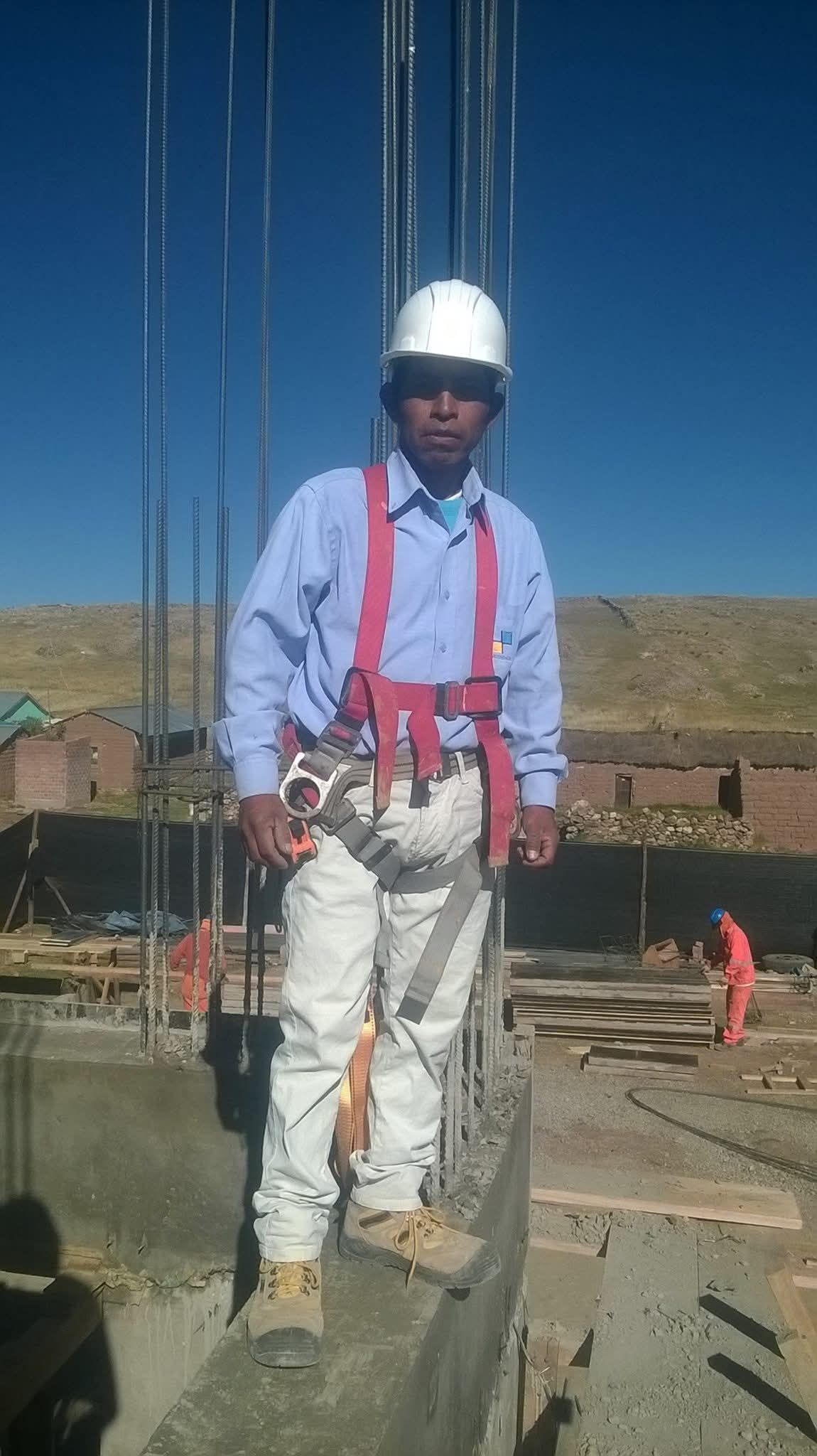 Un trabajador de la construcción con casco blanco y arnés de seguridad