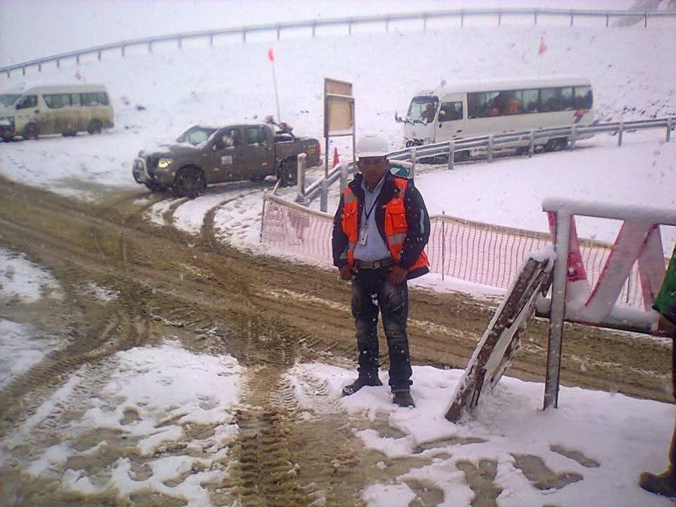 Un hombre con chaleco de seguridad se encuentra cerca de una carretera 