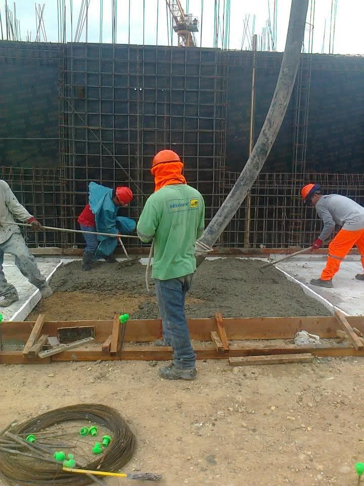 Obreros vierten hormigón en una obra. 