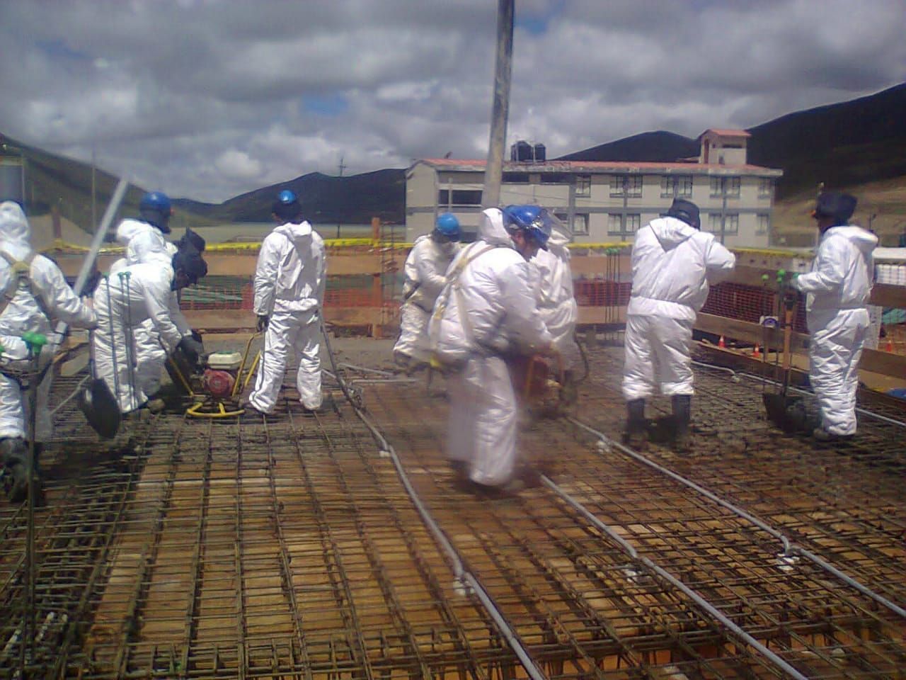 Obreros de la construcción con trajes protectores blancos