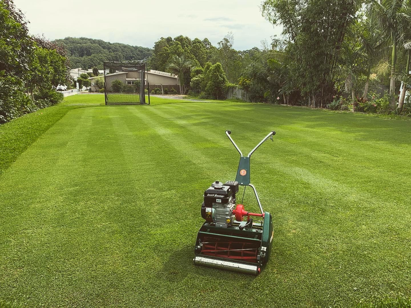 A Lawn Mower Is Sitting on Top of A Lush Green Lawn — All Round Ground Maintenance in Woolgoolga, NSW