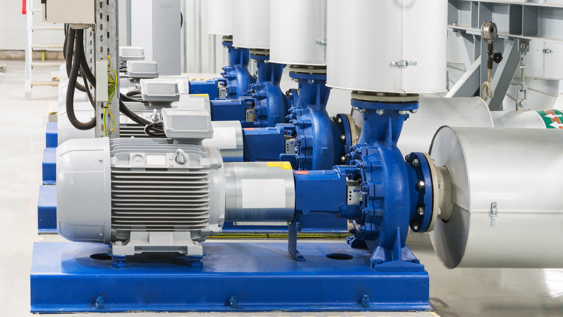 A row of water pumps are lined up in a factory.