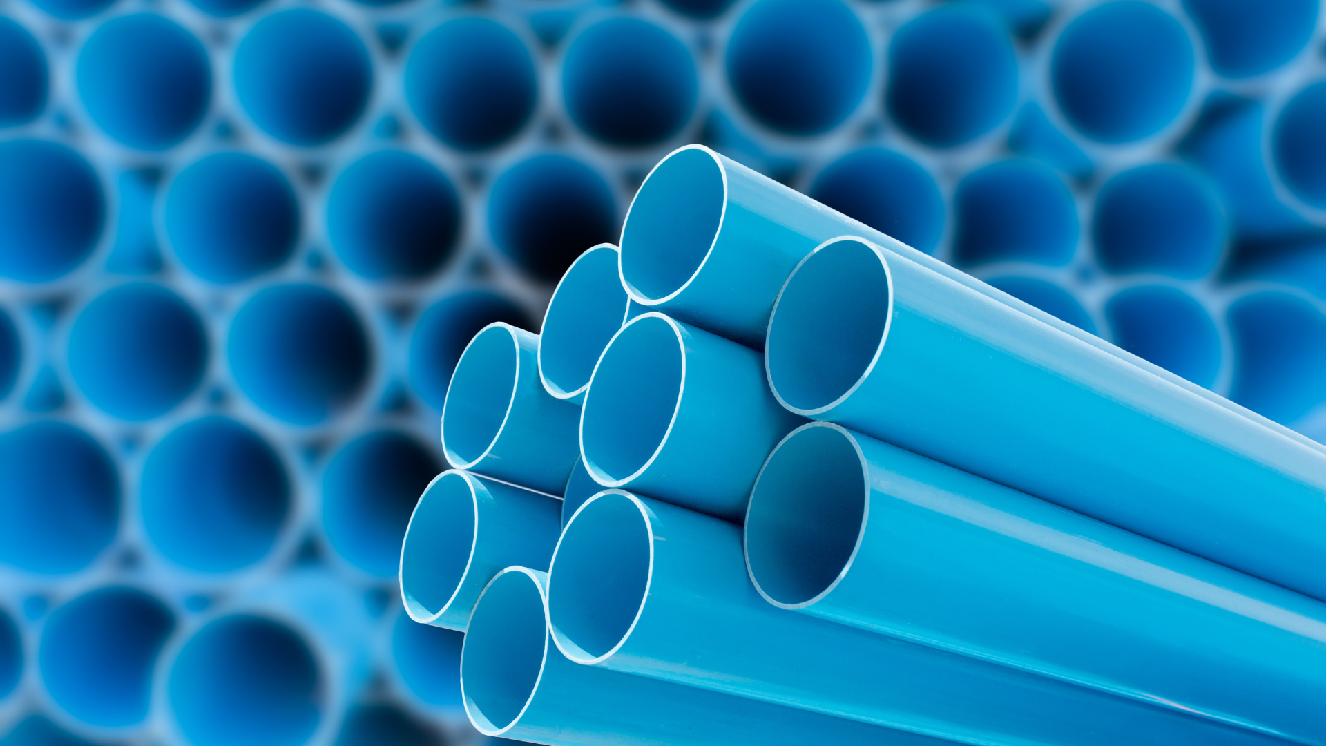 A bunch of blue pipes are stacked on top of each other.