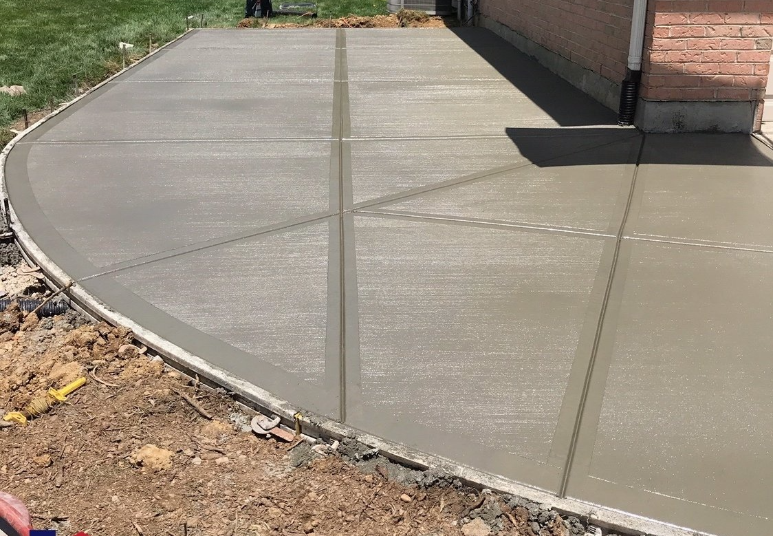 A concrete driveway is being built in front of a house.