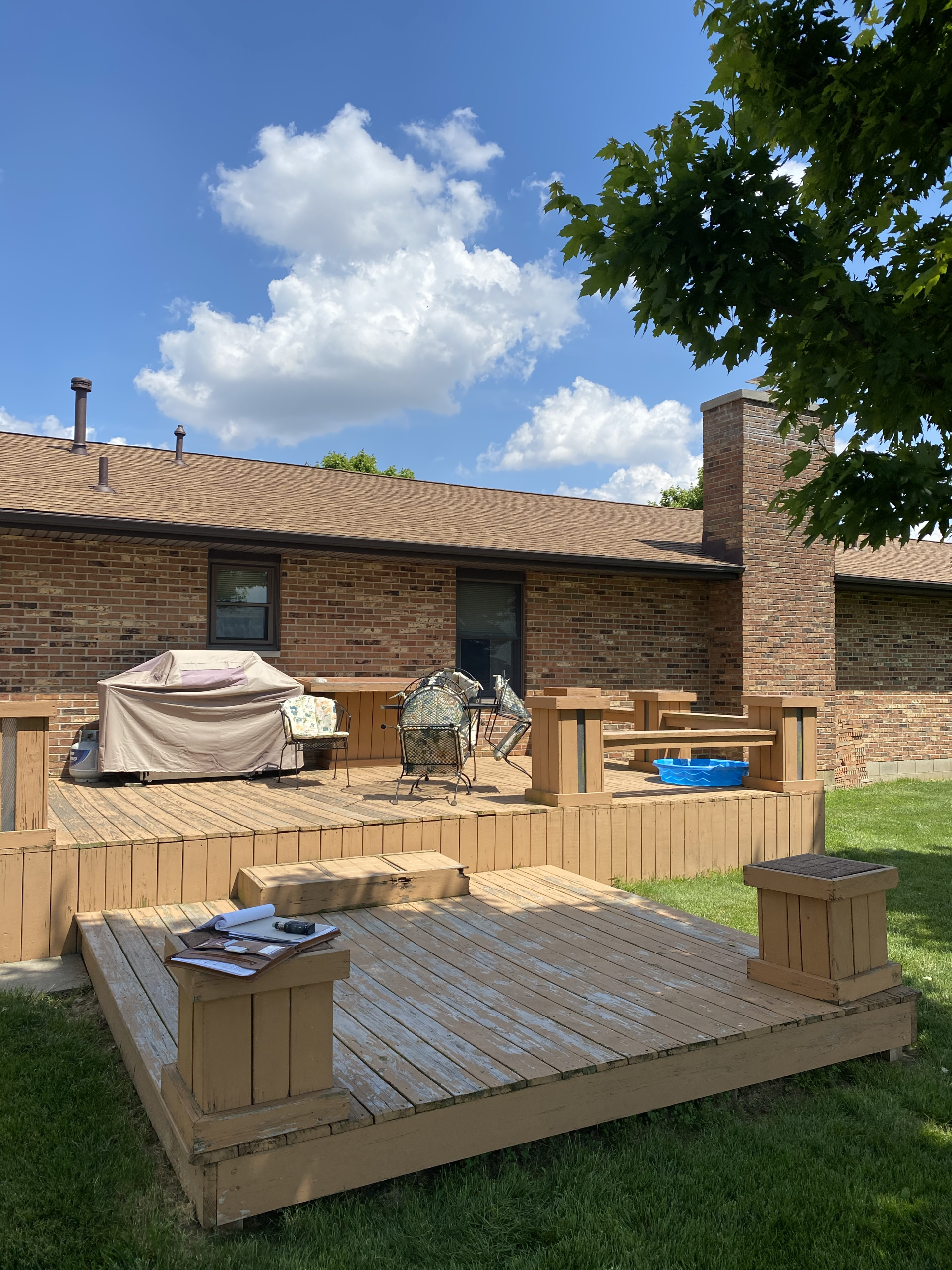 A brick house with a wooden deck in front of it.