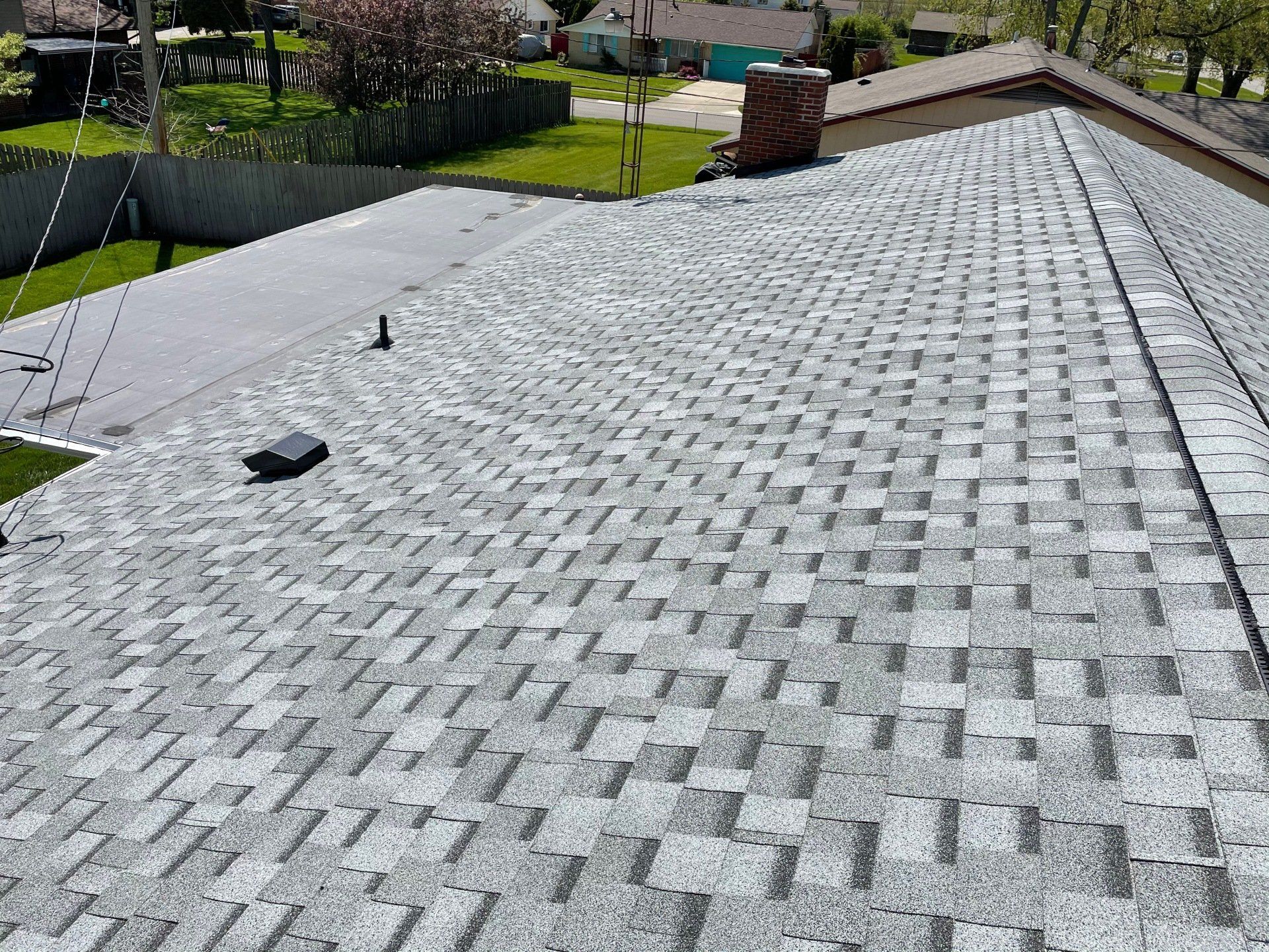 An aerial view of a roof with shingles and a chimney.