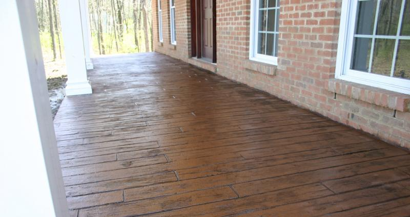 A brick house with a concrete porch and a brick wall.