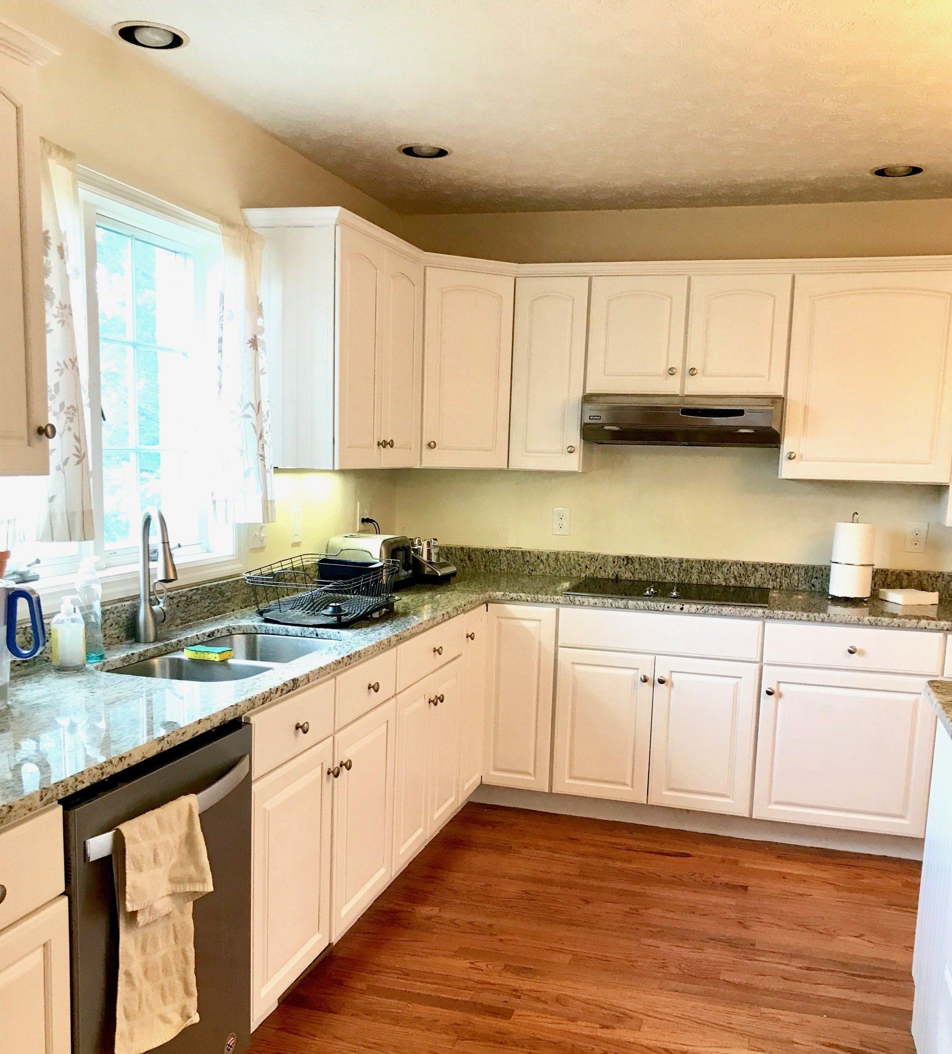 A kitchen with white cabinets and granite counter tops