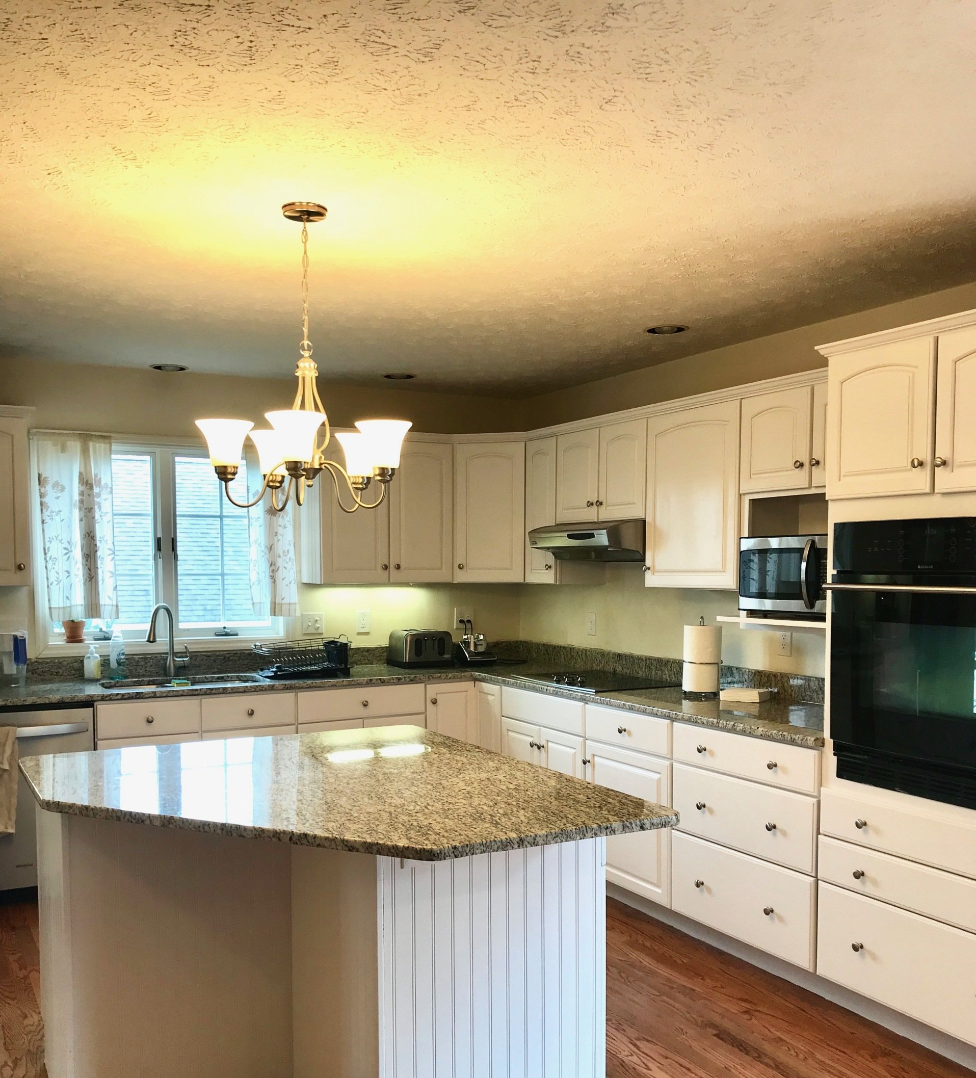 A kitchen with white cabinets and granite counter tops