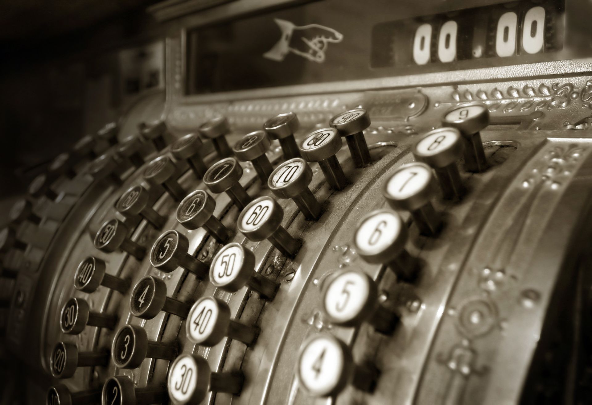 Old cash register with number keys, sepia toned.