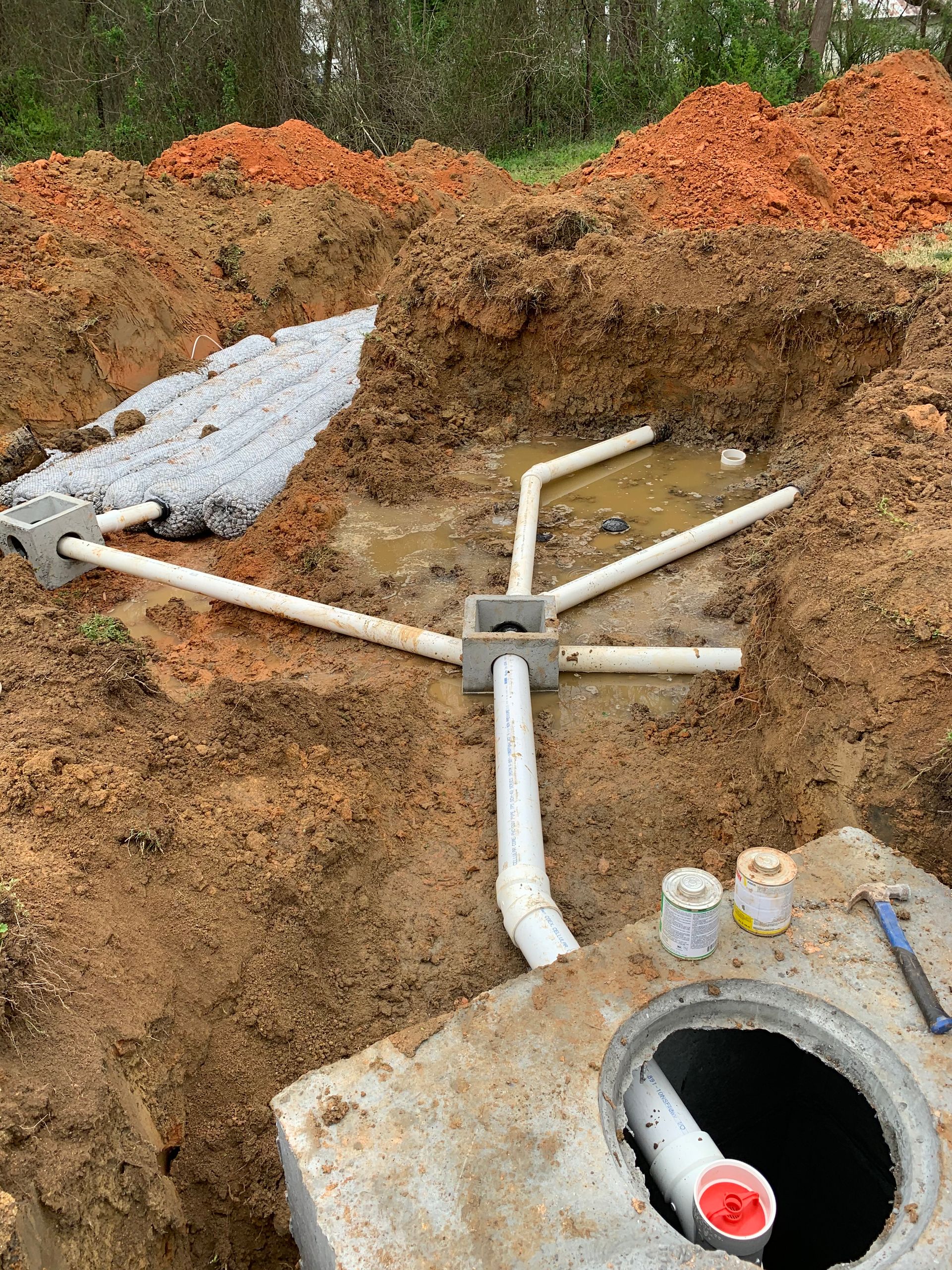 A person is cleaning a hole in the floor with a hose.
