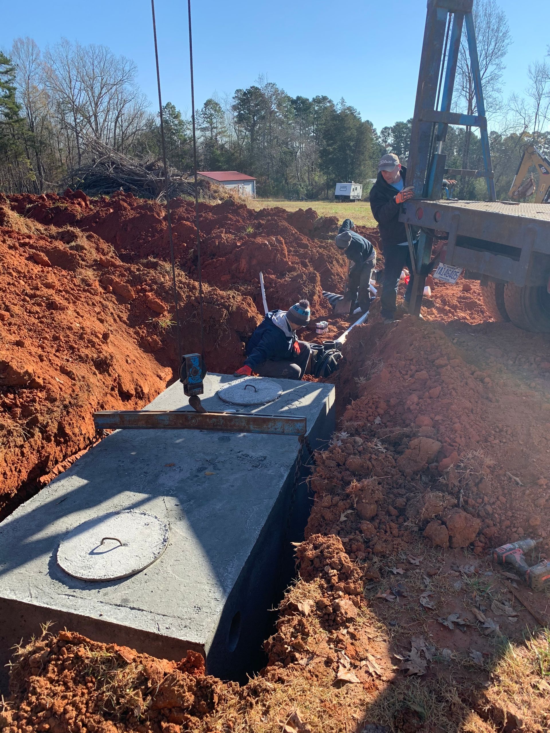 Three black tanks are sitting in a hole in the ground.