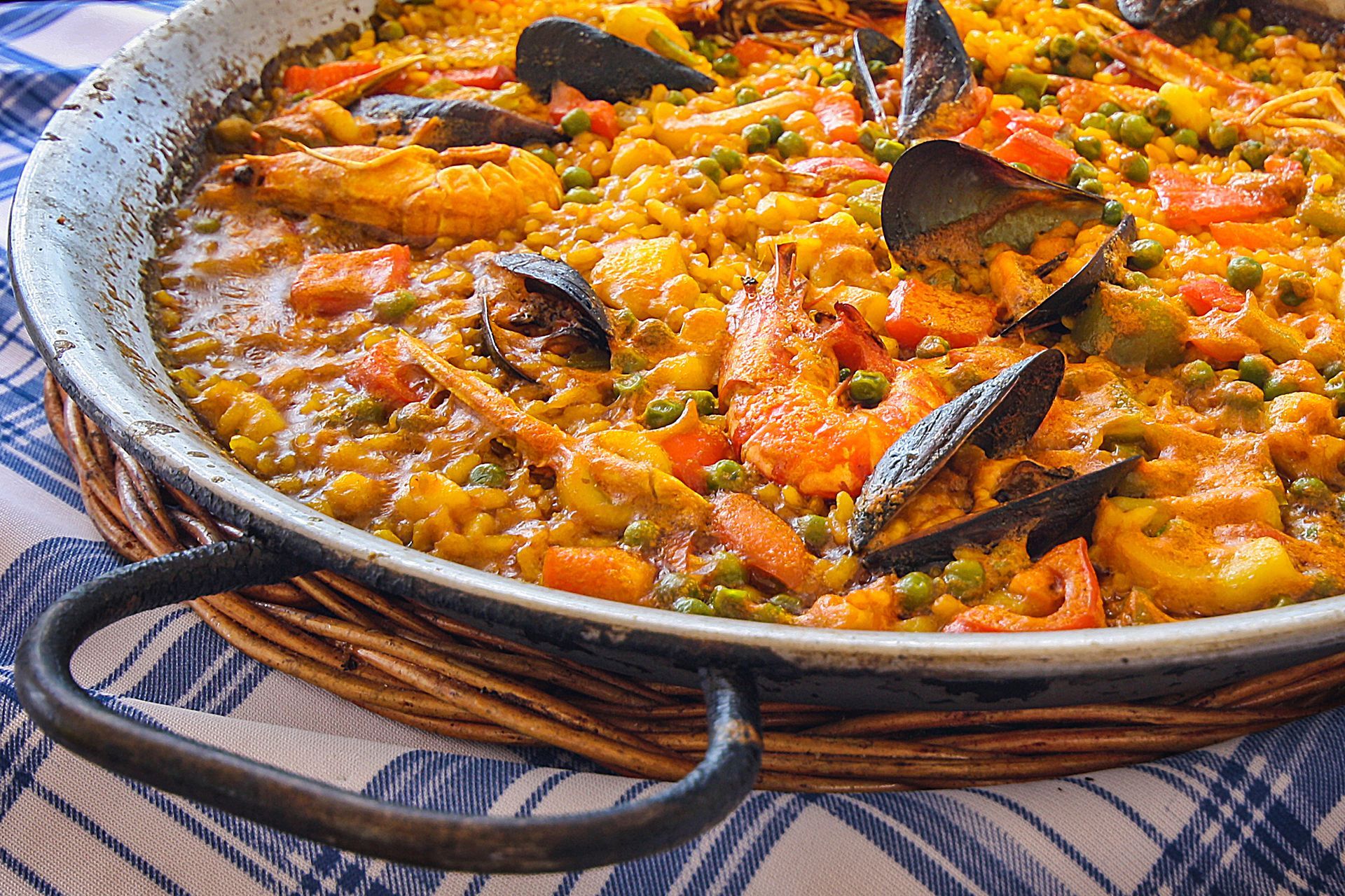 Una padella di paella con cozze, gamberi, piselli e carote