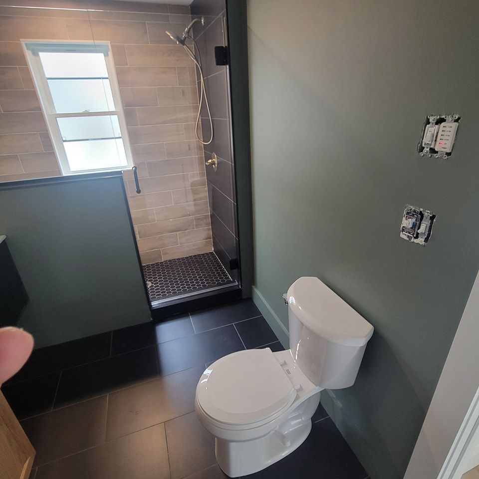 A bathroom with a toilet and a shower.