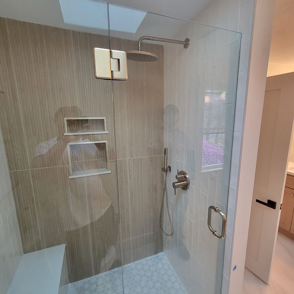 A shower with a glass door and a shower head.