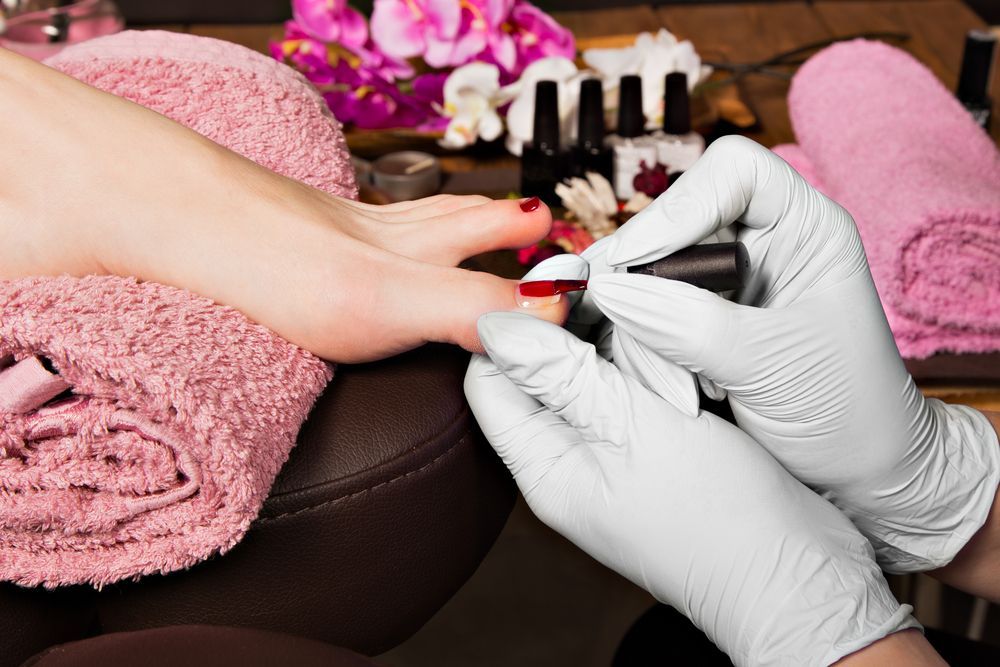 Person Getting a Pedicure With Red Nail Polish Applied in a Spa Setting — Sage Spa & Beauty in Mackay, QLD