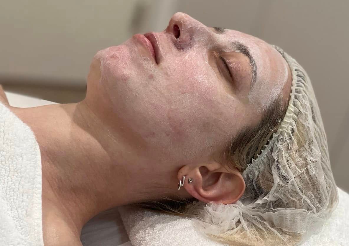 Woman With Closed Eyes, Wearing a Hair Net and Facial Treatment, Lying on a Spa Bed — Sage Spa & Beauty in Mackay, QLD