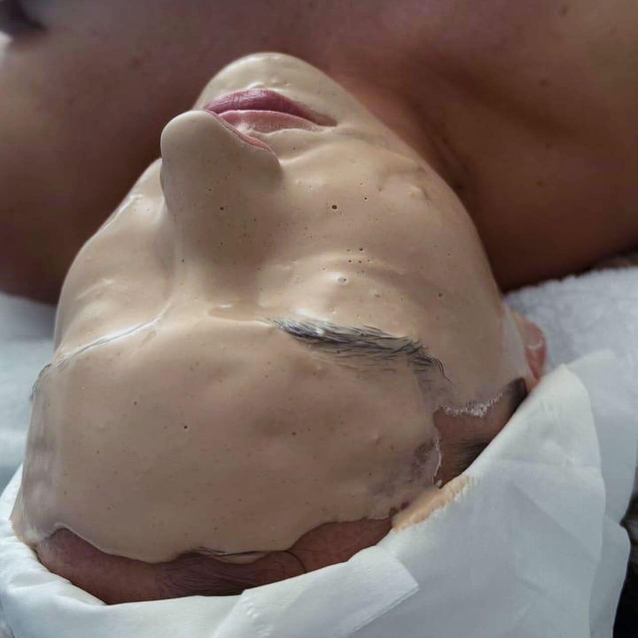 Person With Face Covered in a Beige Facial Mask, Lying on a White Towel — Sage Spa & Beauty in Mackay, QLD