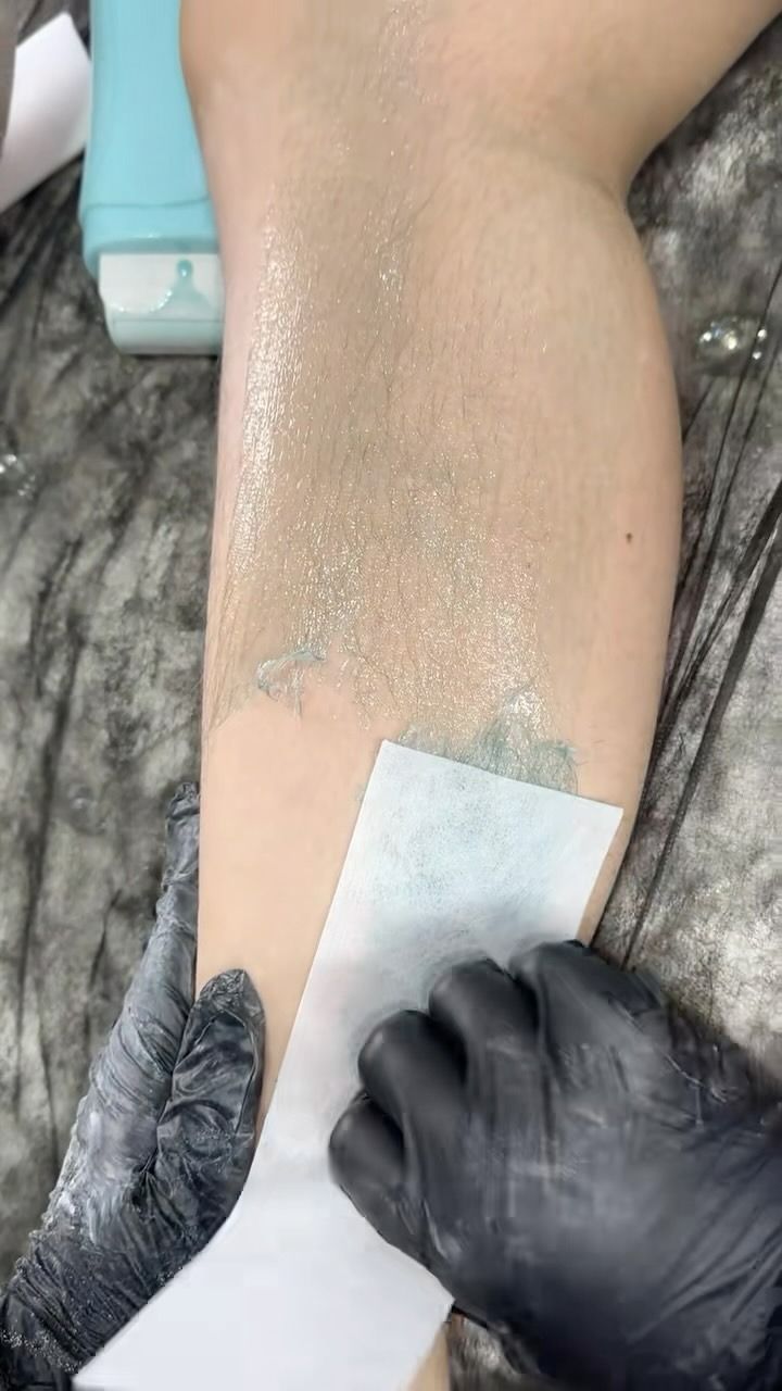 Leg Being Waxed; Gloved Hand Holding Strip to Remove Hair — Sage Spa & Beauty in Mackay, QLD