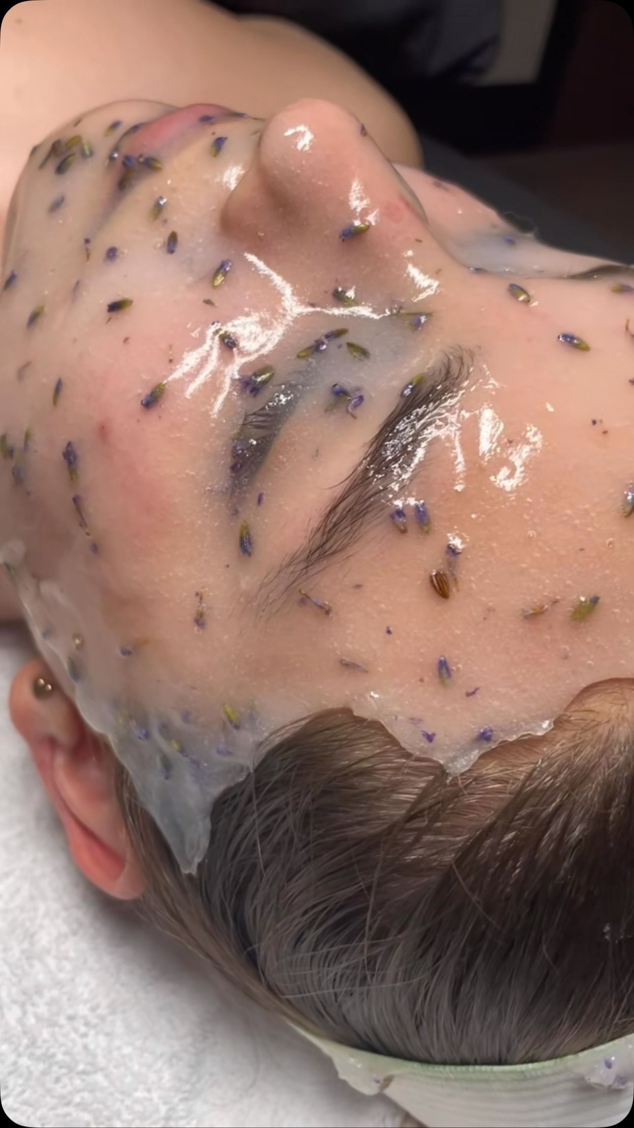 Person With a Facial Mask; Face Covered in a Lavender-infused Gel, Lying on a White Towel — Sage Spa & Beauty in Mackay, QLD