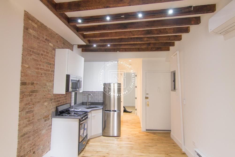 A kitchen with a stainless steel refrigerator , stove , and microwave.