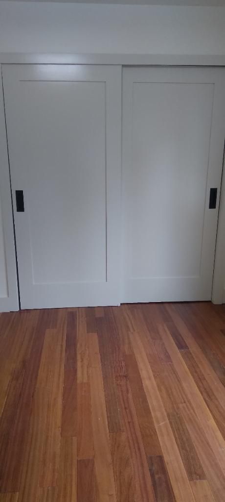 A room with hardwood floors and white sliding doors.