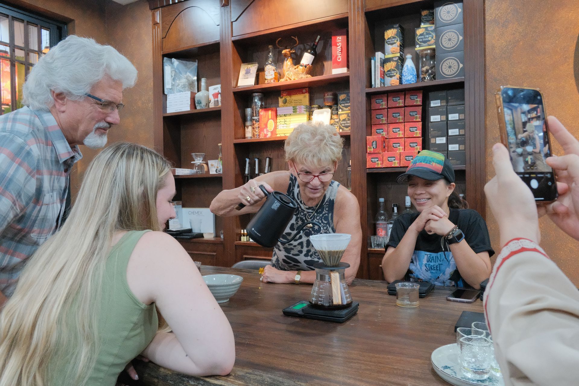 A group of people participating in a coffee brewing workshop at Local Beans Roastery, with a table full of brewing tools and a cozy, welcoming atmosphere.