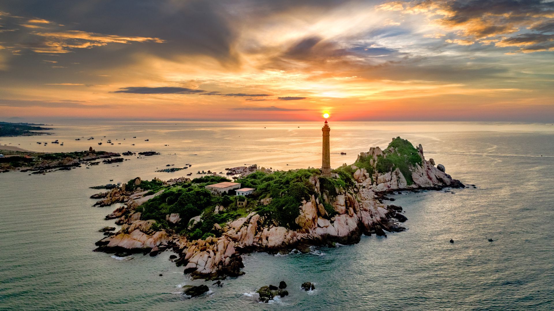 A majestic lighthouse standing on a Vietnamese island in the middle of the sea, guiding vessels at dusk.