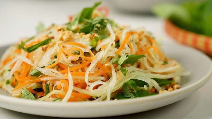  A vibrant Vietnamese vegan papaya salad with shredded green papaya, carrots, herbs, and crushed peanuts.