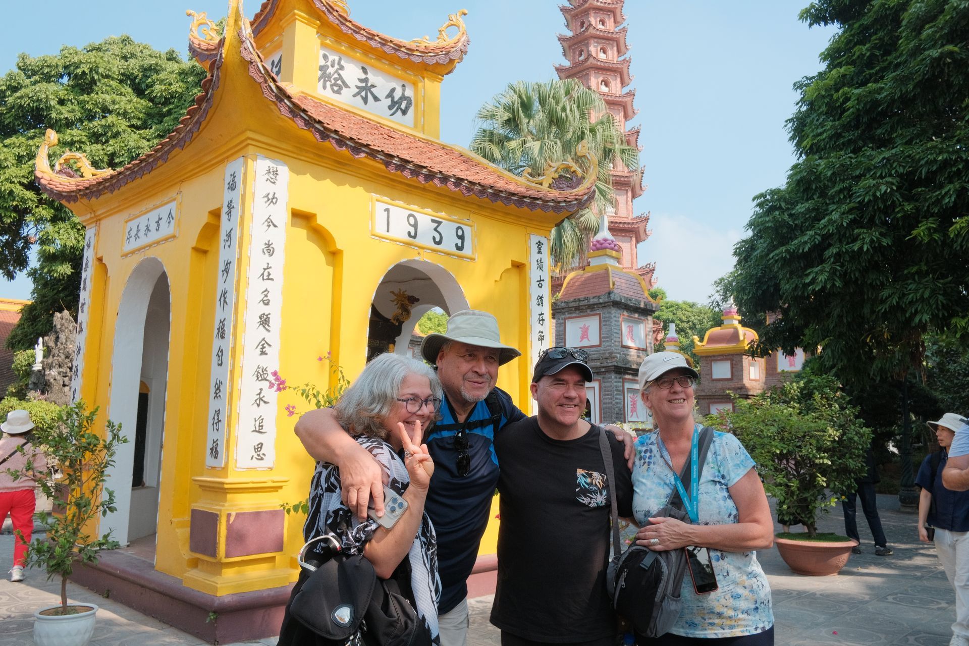 Visitors exploring a beautiful pagoda in Vietnam, surrounded by lush greenery and intricate architecture.