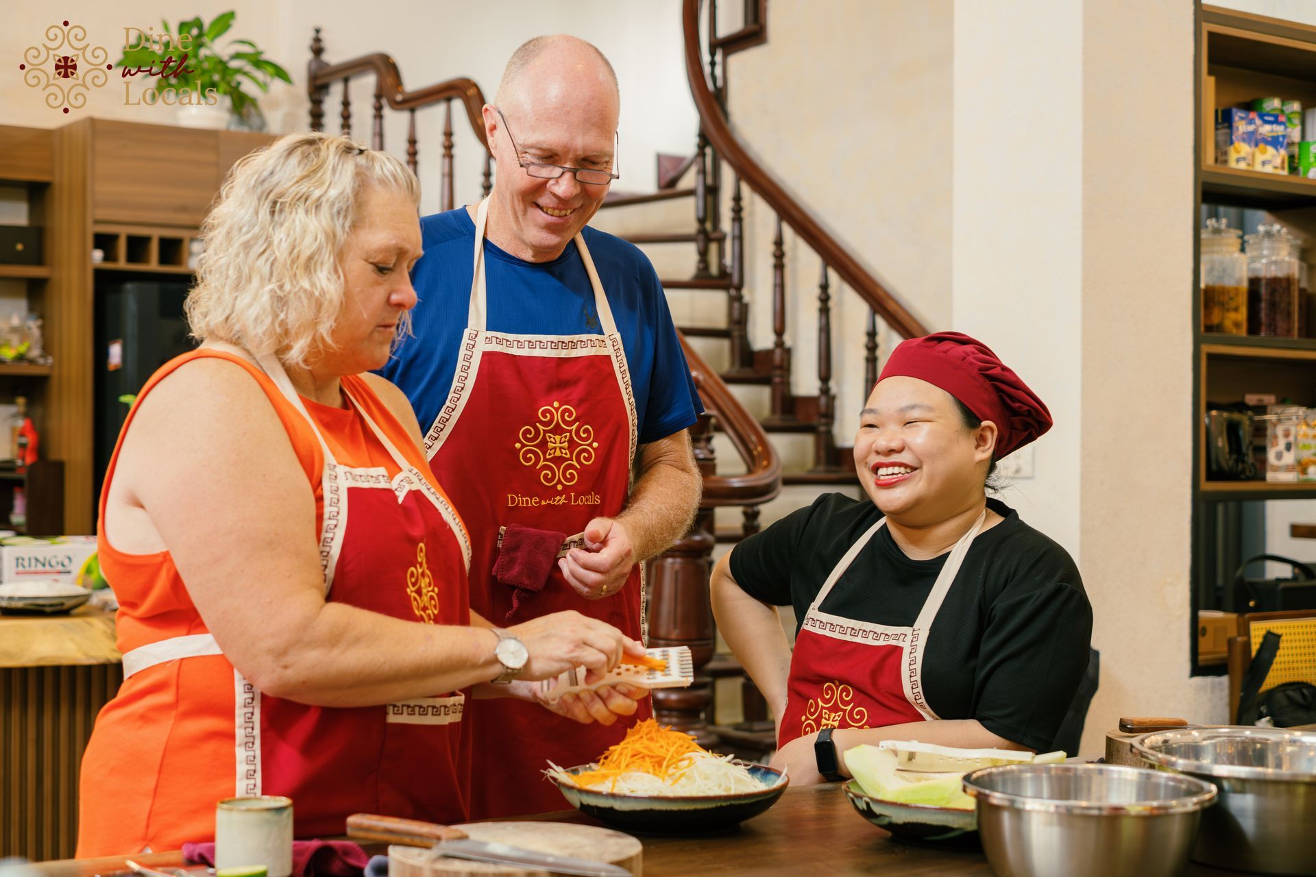 Tourists learning to prepare Vietnamese dishes under the guidance of a local chef during a cooking class in Hanoi.