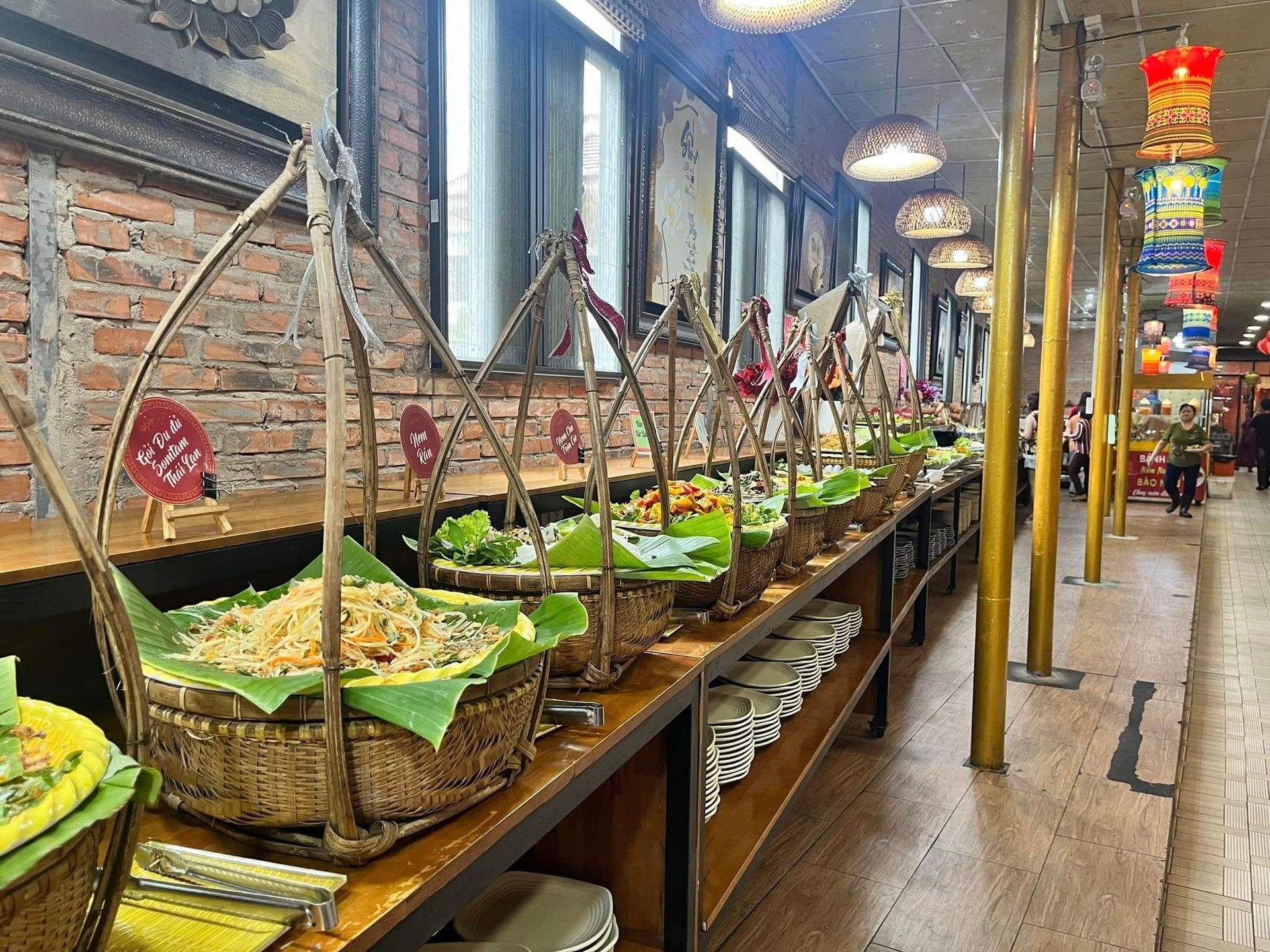 A buffet display at Thien Y Vegan Restaurant with traditional baskets of fresh vegan dishes.