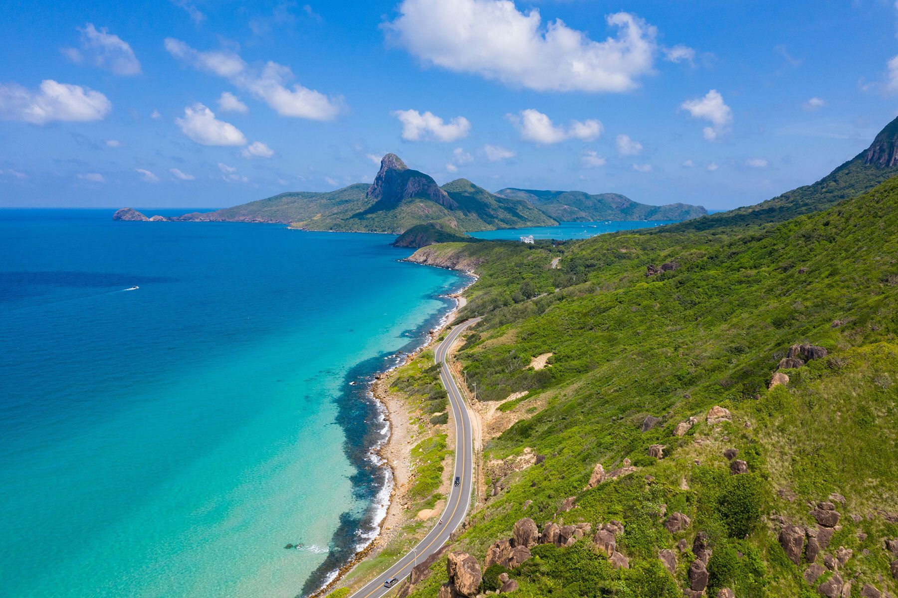 A picturesque coastal road in Con Dao under a clear sky.