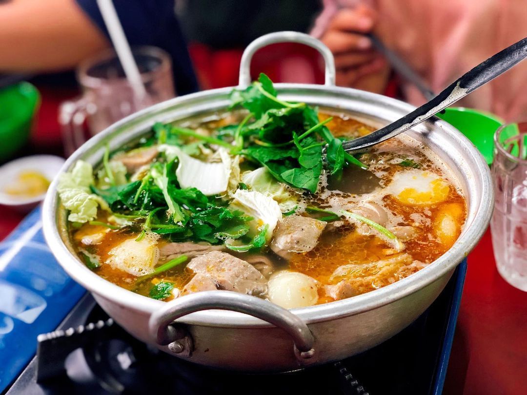 Vietnamese beef hotpot with vegetables and meat simmering in broth.