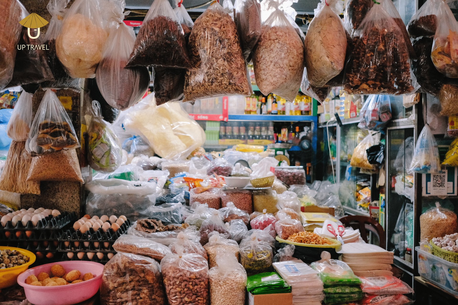 Dry goods display at a Vietnamese market, featuring spices, dried fruits, and grains