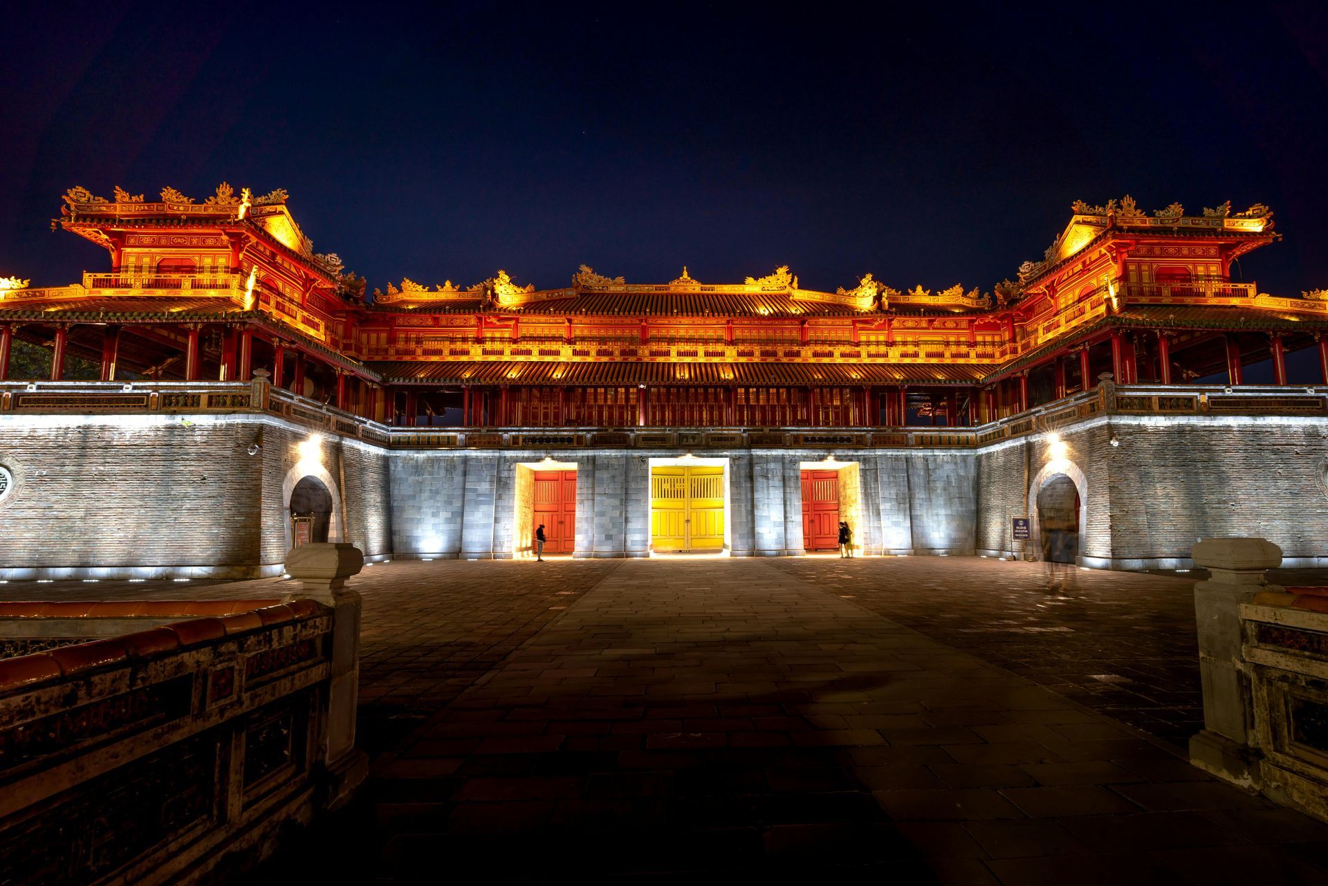 The Imperial City of Hue illuminated beautifully at night with vibrant red and yellow doors.