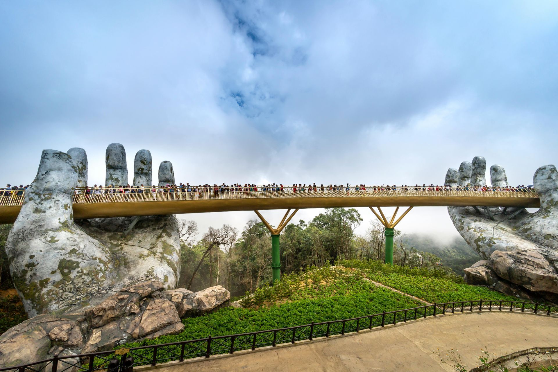 The Golden Bridge in Da Nang, Vietnam, held by giant stone hands.