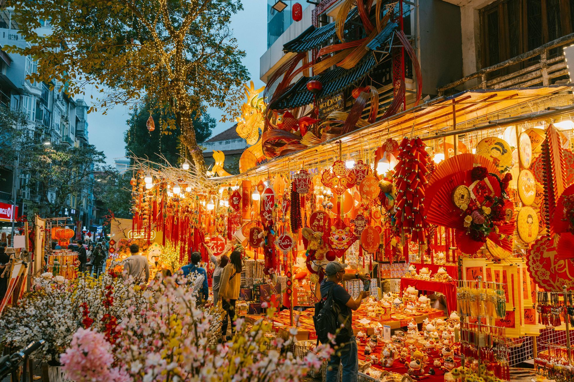 A dazzling view of Hang Ma Street during Tet, filled with vibrant colors, festive decorations, and sparkling lights.