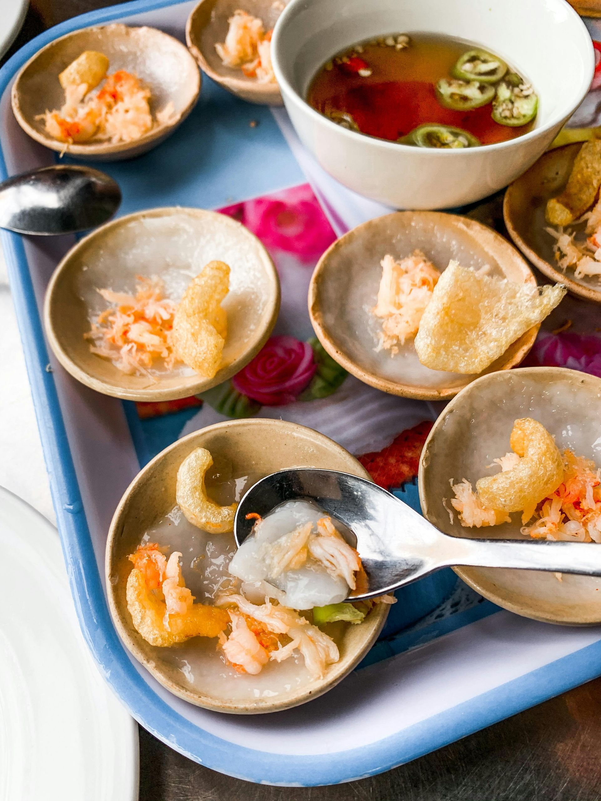 Vietnamese Banh beo, steamed rice cakes topped with savory toppings, served on a tray.