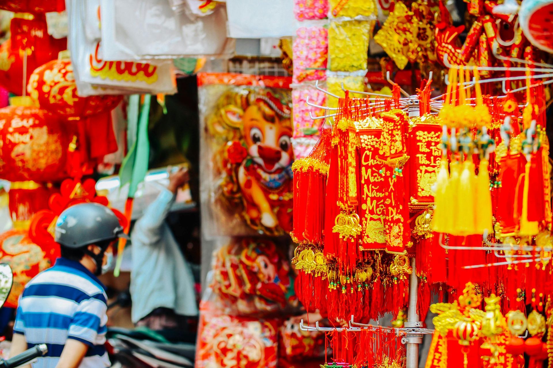 A vibrant Tet decoration shop on Hang Ma Street, Hanoi, filled with red and gold ornaments.