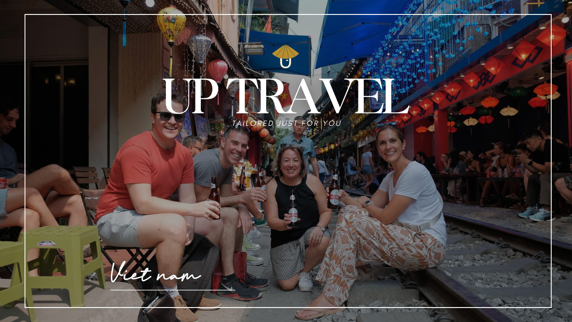 Group of international tourists enjoying drinks along Hanoiβs Train Street, surrounded by colorful l