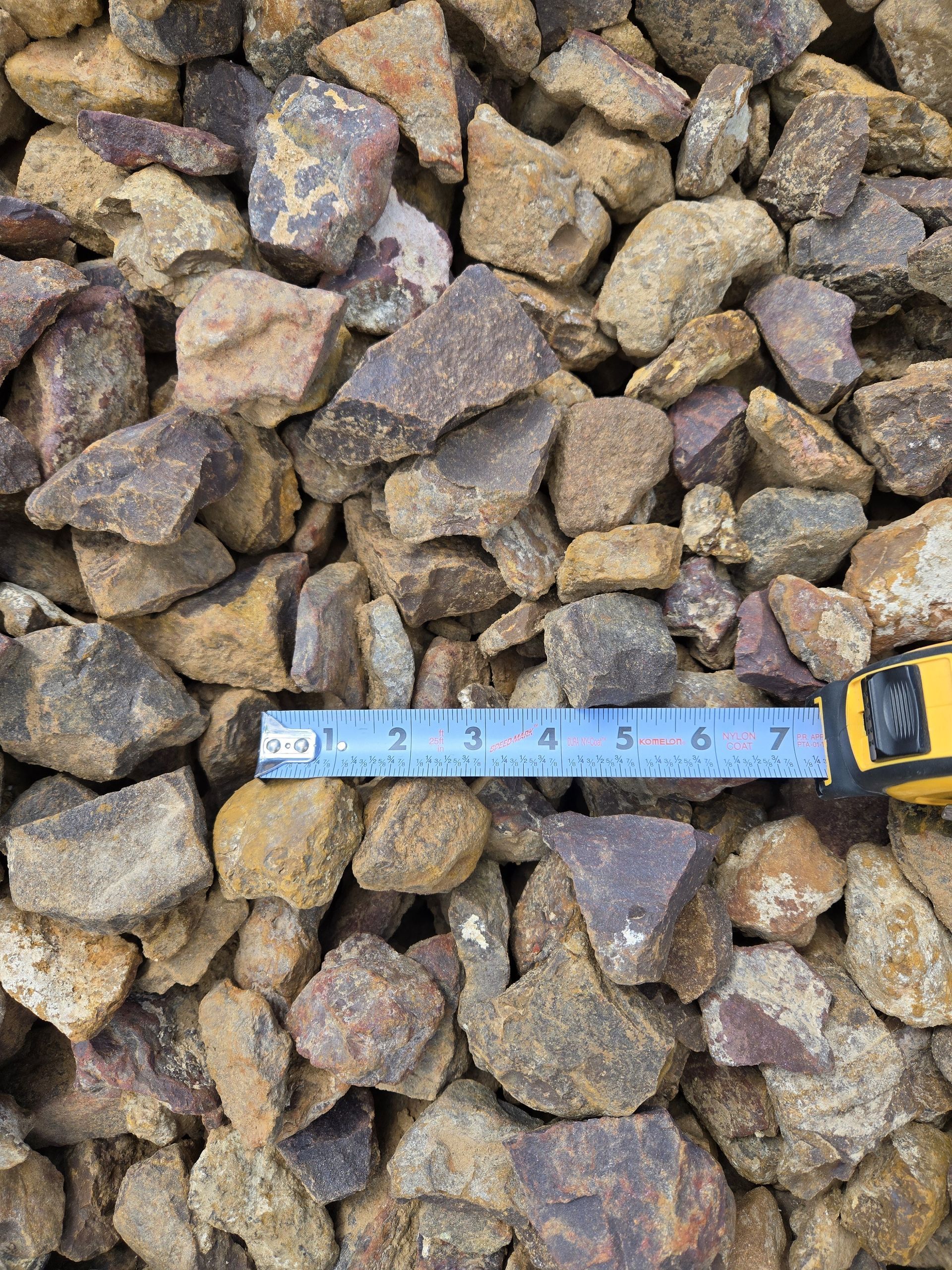 A tape measure is sitting on top of a pile of rocks.