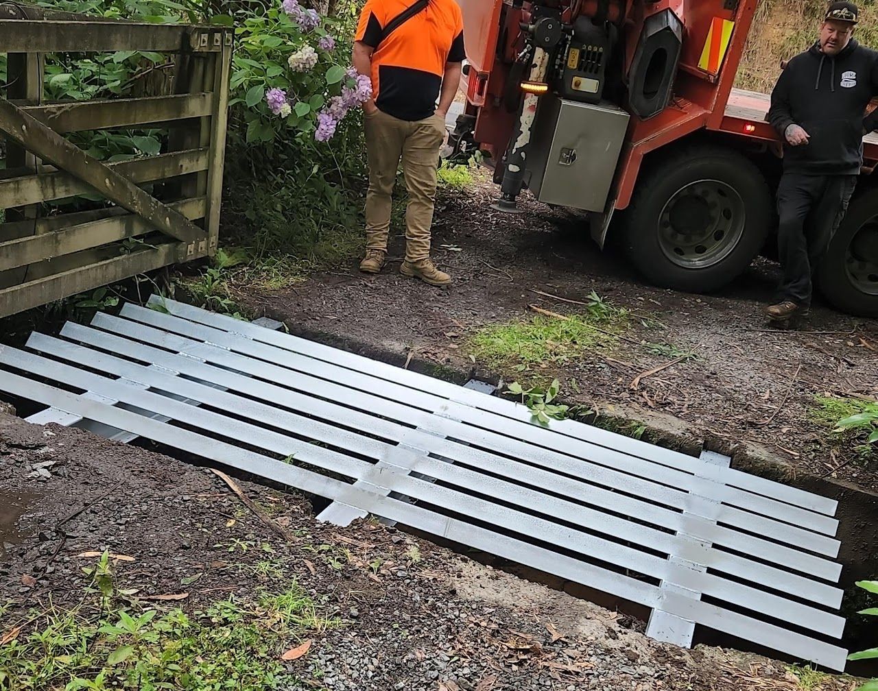 A man is standing next to a truck with a fence in the background.
