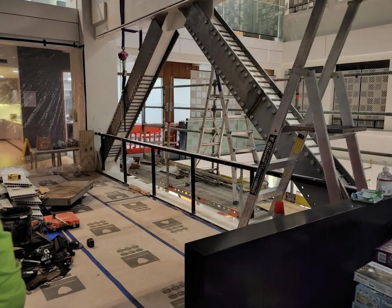A staircase is being built in a building with a ladder in the foreground.