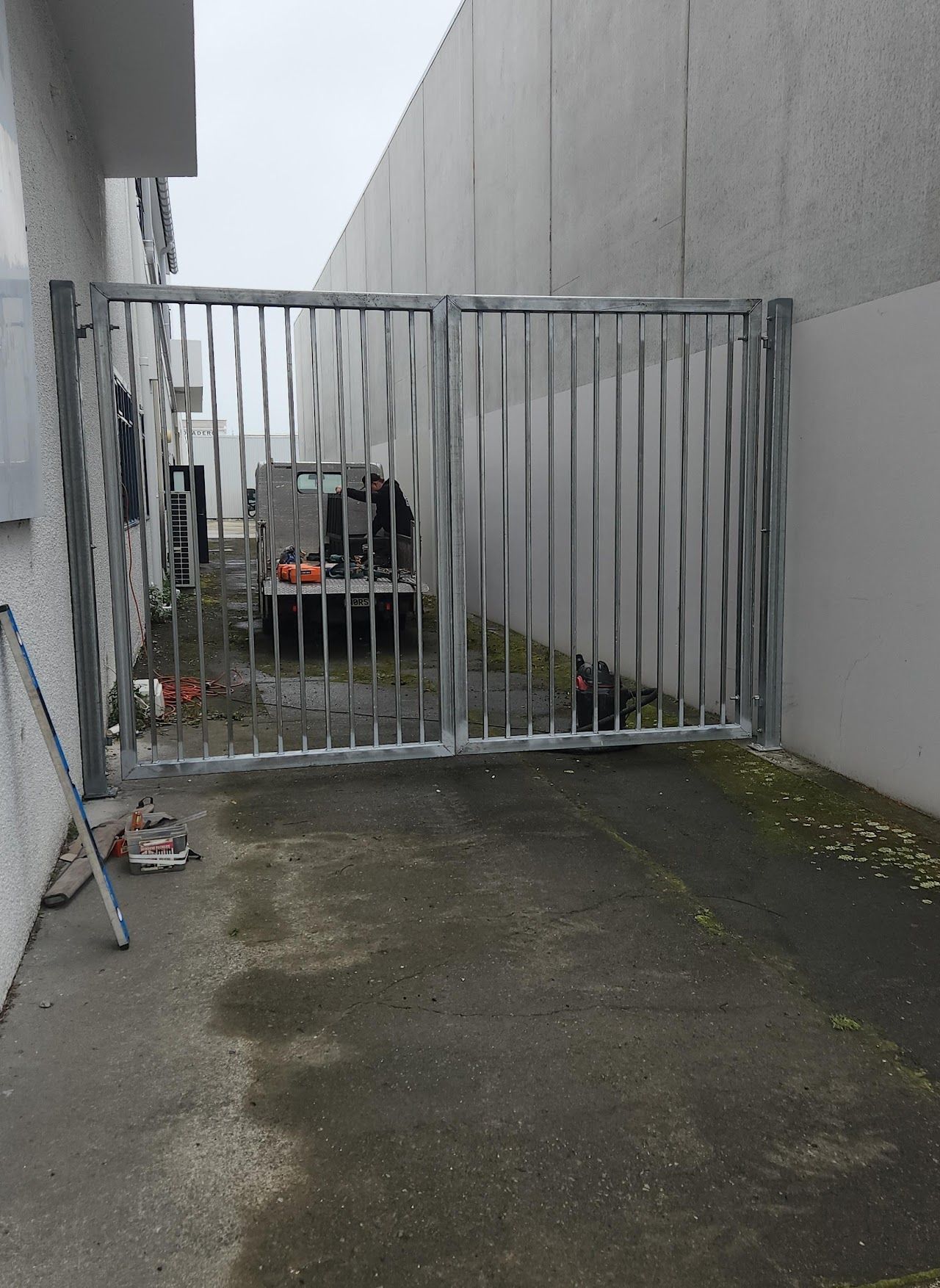 A car is parked behind a gate in a parking lot.