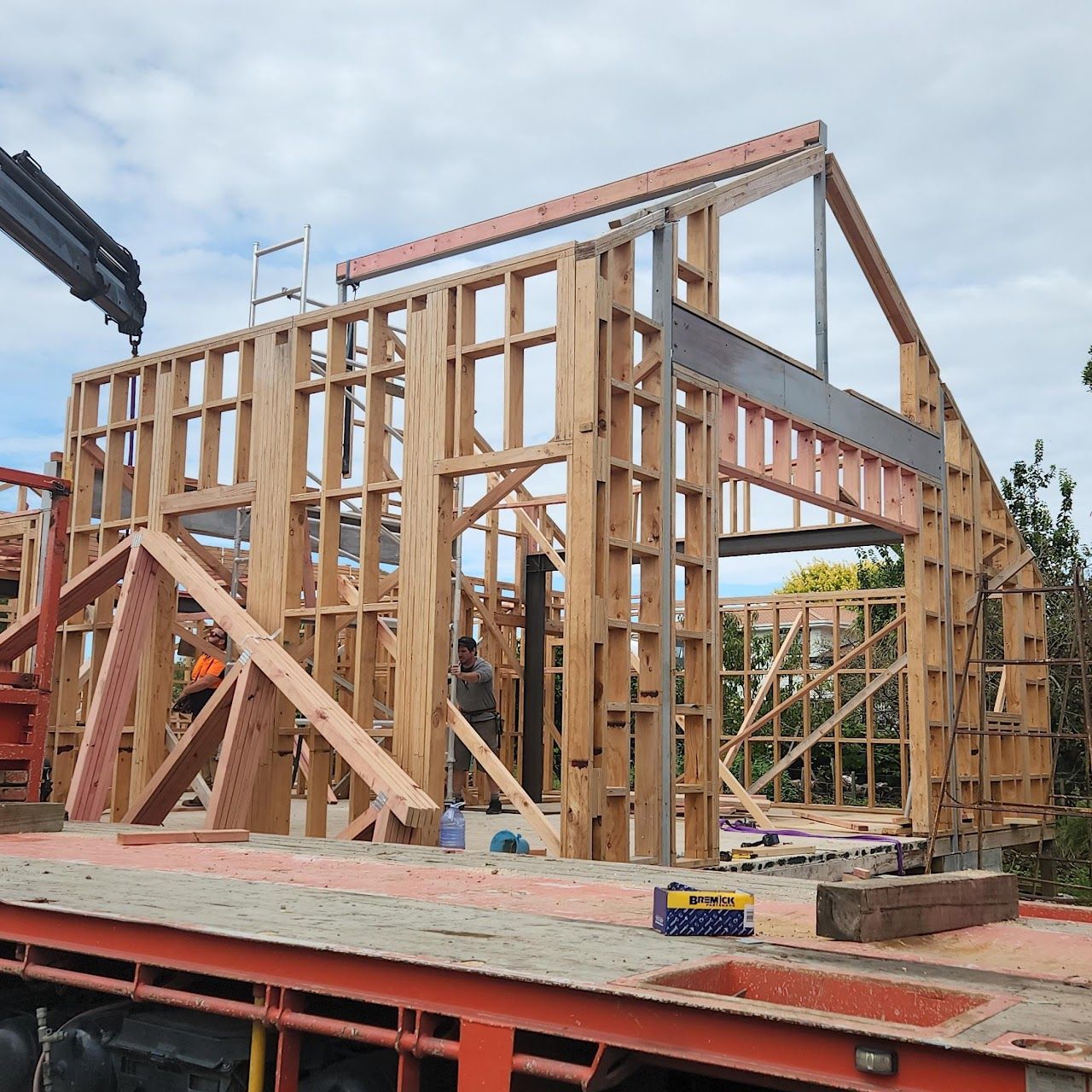 A large wooden structure is being built with a crane in the background.
