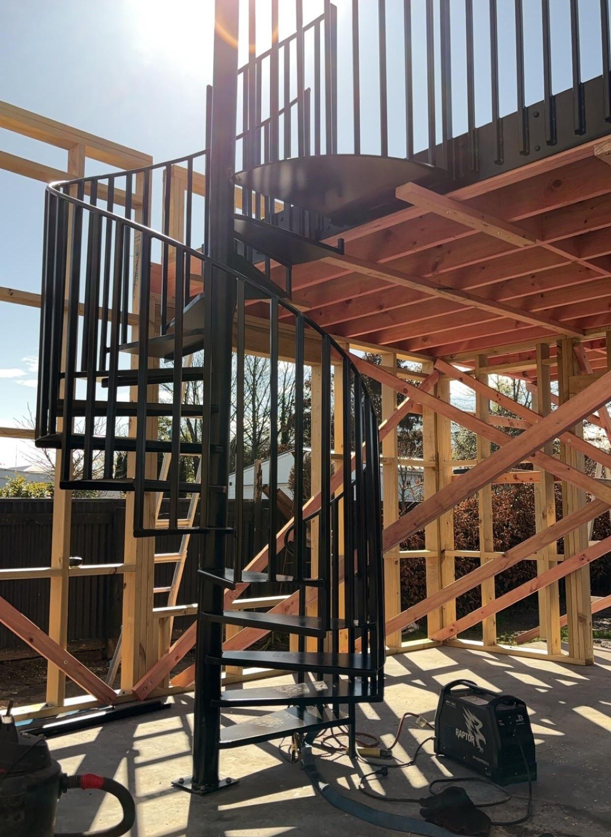 A spiral staircase is being built in a house under construction.