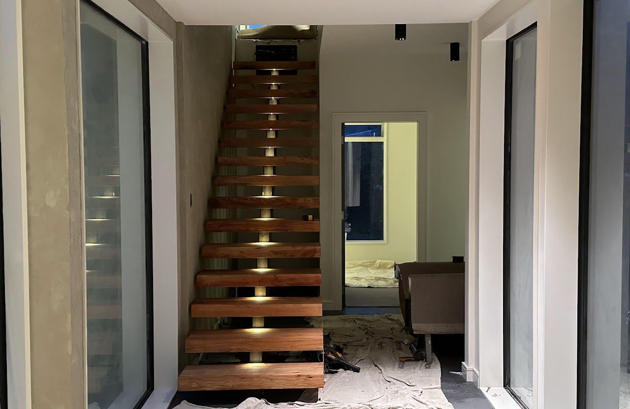 A wooden staircase is leading up to the second floor of a house.