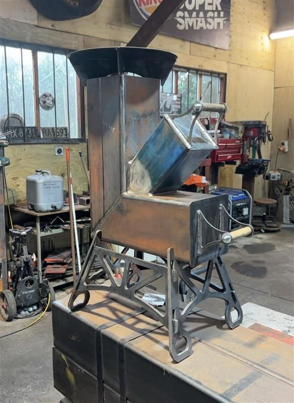 A rocket stove is sitting on a table in front of a sign that says super smash.