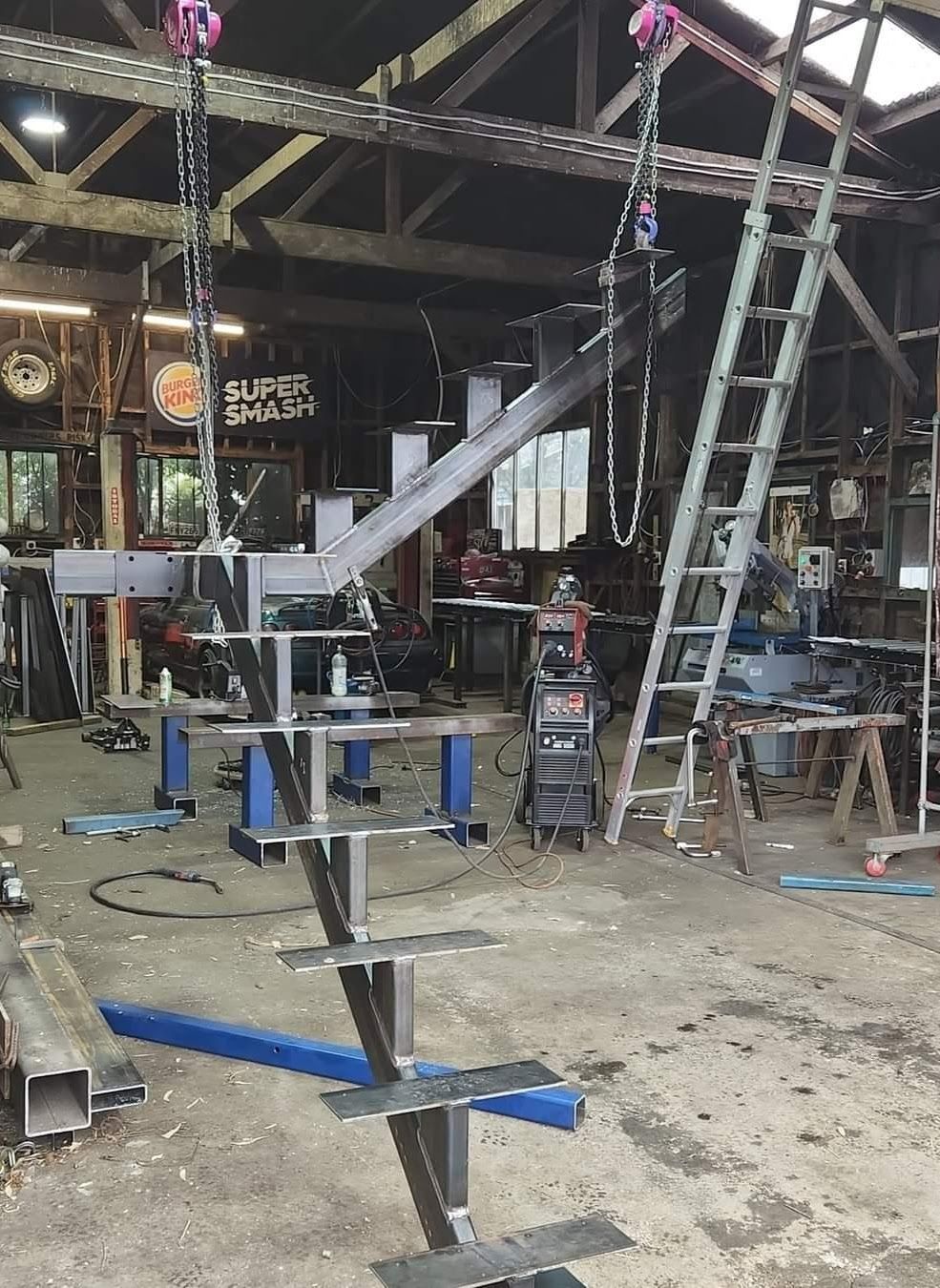 A metal staircase is being built in a factory.